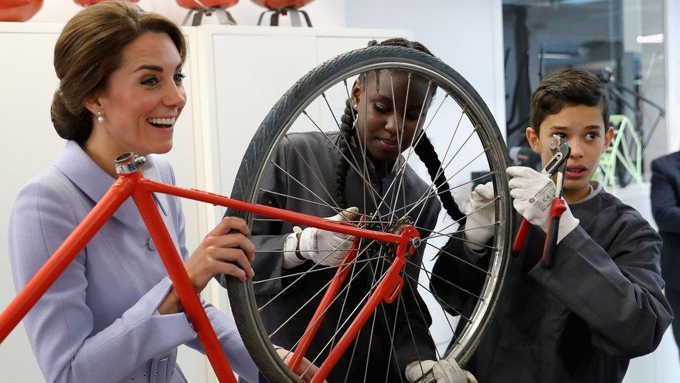 Kate helping to fix a bike wheel