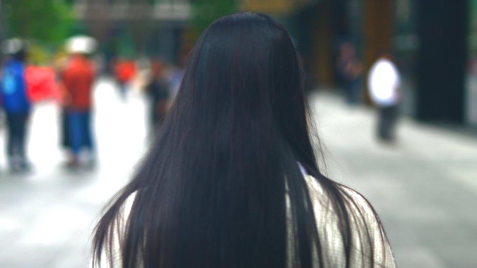 Woman with long hair facing away from the camera