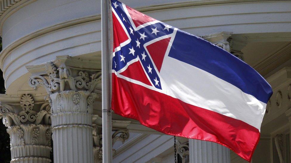 The state flag of Mississippi is unfurled against the front of the Governor's Mansion in Jackson, Miss., Tuesday, June 23, 2015