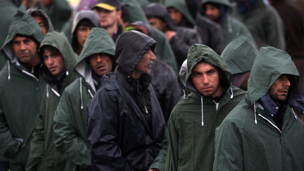 Migrants wait at the closed Macedonian border in Idomeni, northern Greece, 8 March