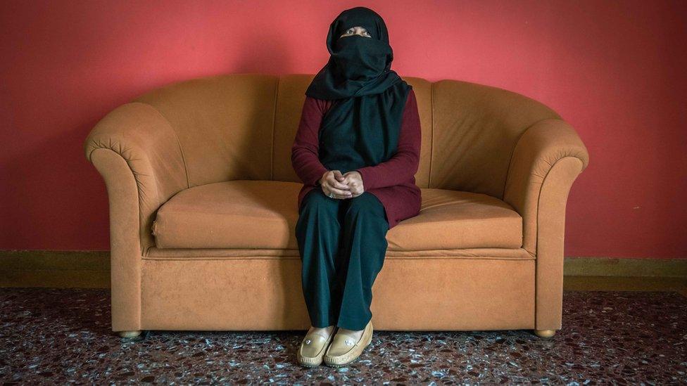 Sana sits defiant on the sofa of her temporary accommodation in Greece.