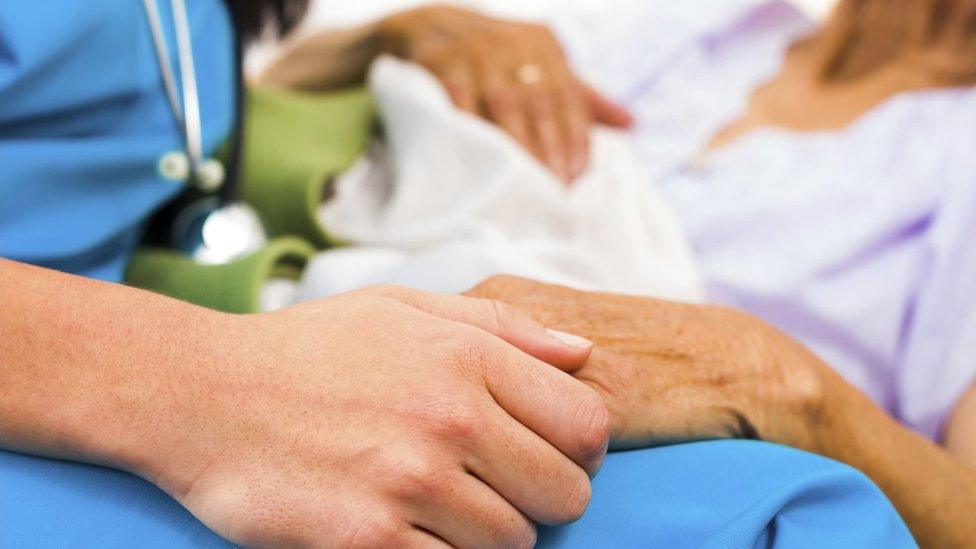 Nurse holding patients hand