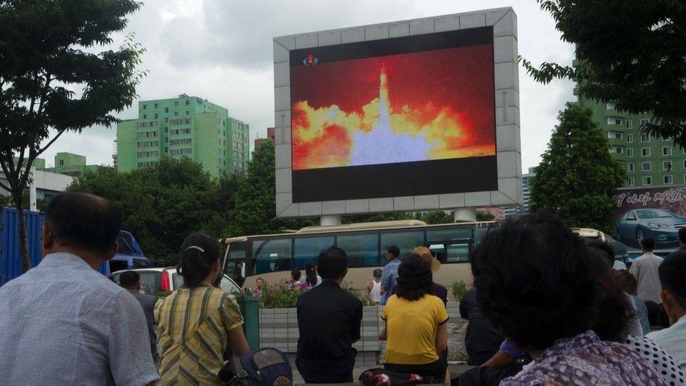 People in the North Korean capital Pyongyang watch coverage of an ICBM missile test on July 29, 2017