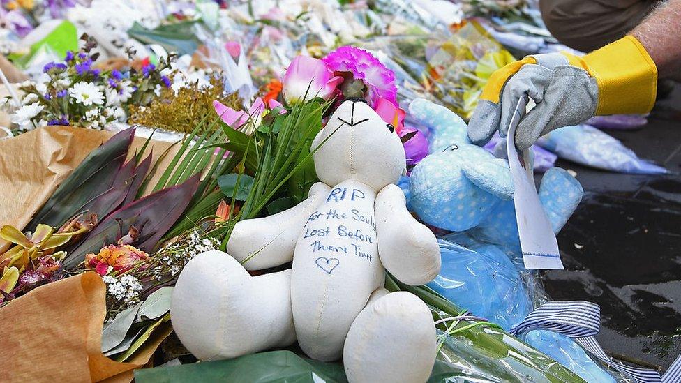 Volunteers carefully dismantle a makeshift memorial on Tuesday