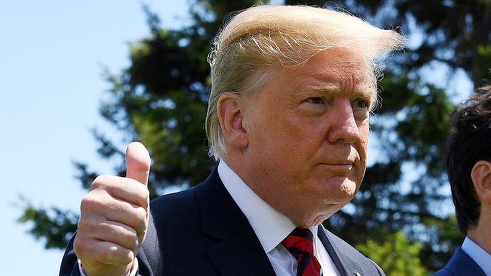 US President Donald Trump gives a thumbs up to the camera. He is standing next to Justin Trudeau, Canadian prime minister.