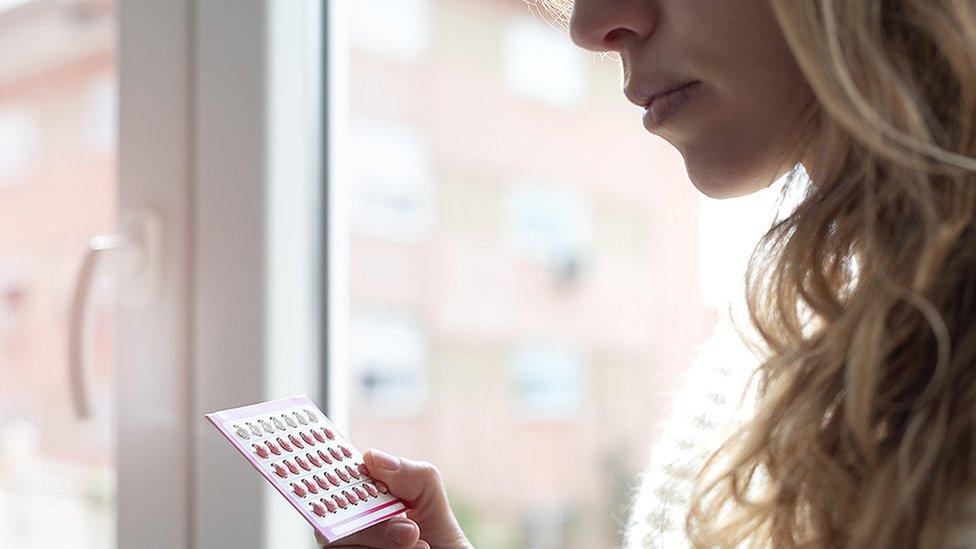 Woman holding contraceptive pills