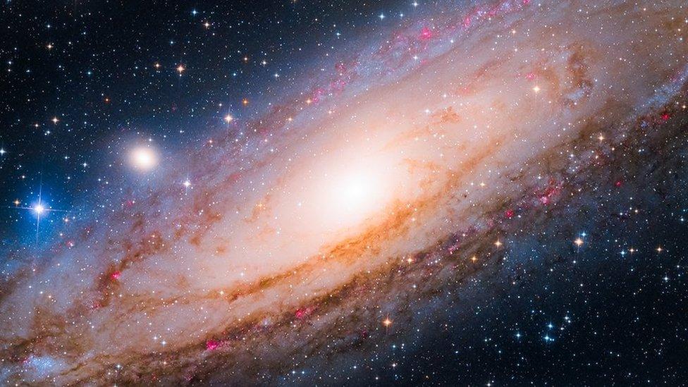 The Andromeda Galaxy, bright light in the middle with millions of stars surrounding