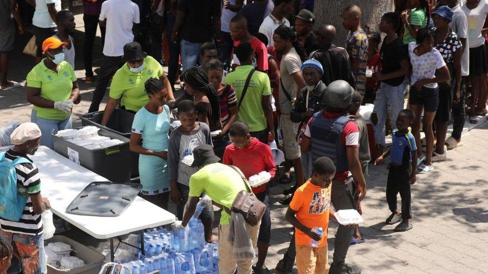 Residents who fled violence gather to receive meals at a school being used as shelter as the government declared state of emergency amid violence, in Port-au-Prince, Haiti, March 4, 2024.