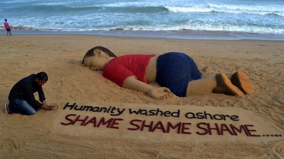 Indian artist Sudarsan Pattnaik works on a sand sculpture depicting drowned Syrian boy Alan Kurdi at Puri beach, some 65 km away from Bhubaneswar, on September 4, 2015.