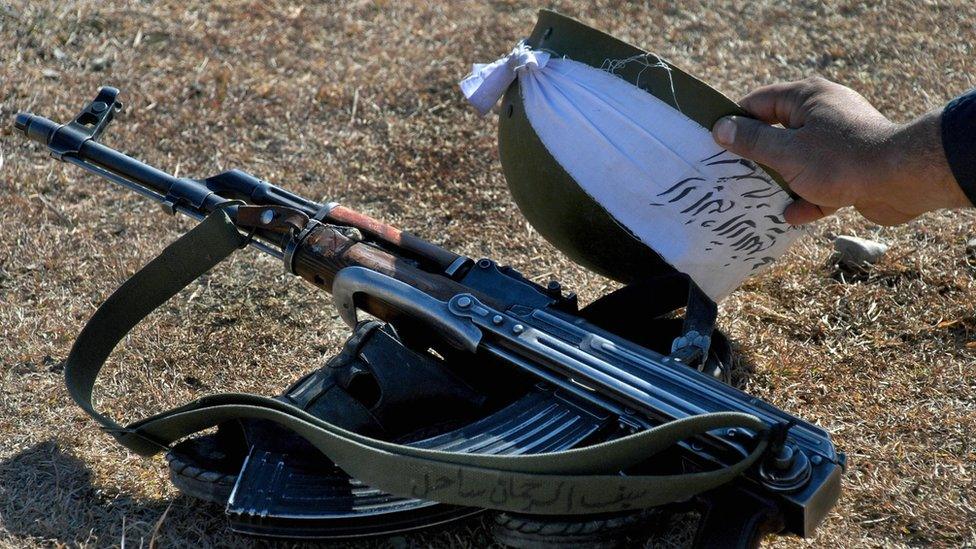 A Pakistani Taliban militant his gun and helmet before a prayer. File photo