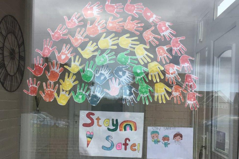 Painted rainbow hands in window