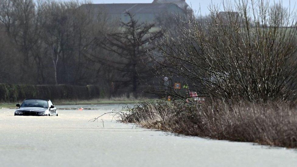 a car stranded in flood waters as the River Dee bursts its banks near Bangor-on-Dee