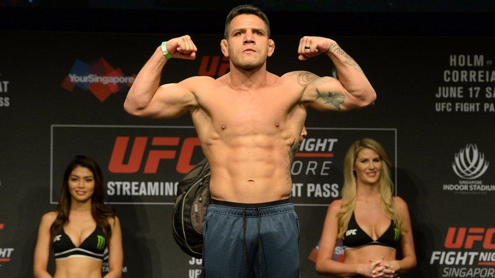 Rafael dos Anjos of Brazil stands on a weighing scale during the UFC Fight Night official weigh-in in Singapore