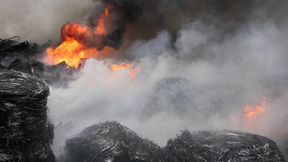 The surface fire was subdued on Monday night, but scrap metal and plastic beneath caused more smoke into Tuesday