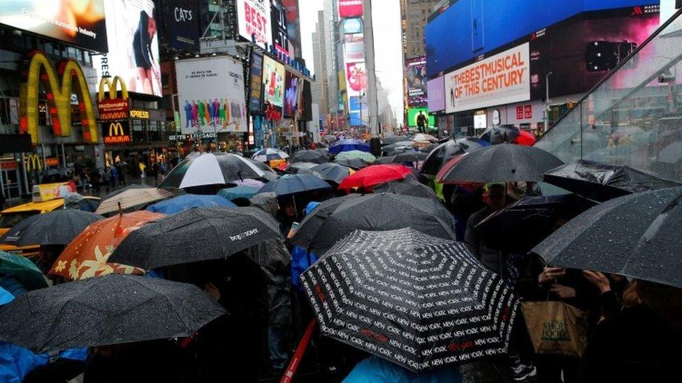 People walk in the rain in Times Square in New York (13 April 2017)