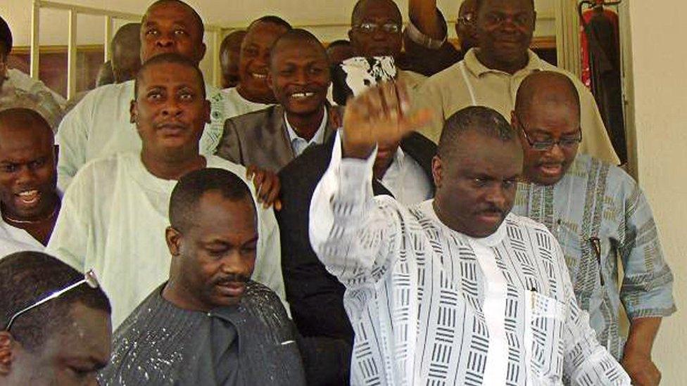 Ibori raises his hand to acknowledge supporters after leaving Asaba High Court in Nigeria's Delta State in 2009