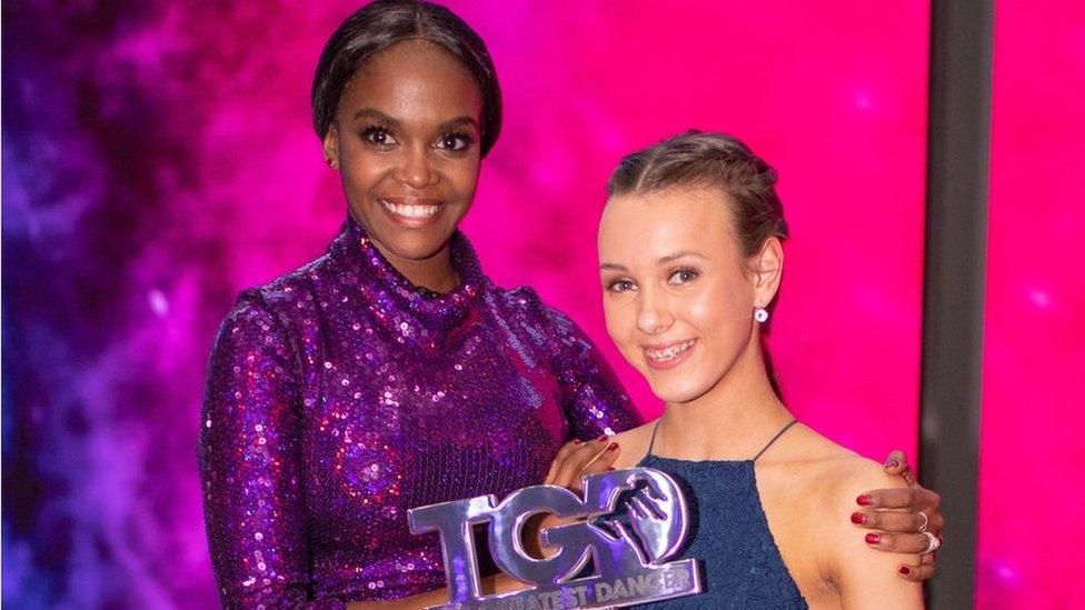 ellie and oti holding the greatest dancer trophy