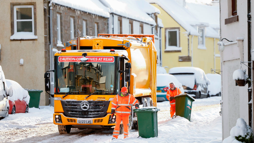 Bin men work in the snow