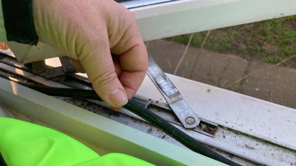 A hand shows where the rubber seal around a window is peeling off