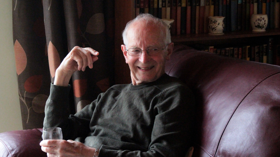 Michael May sitting on a sofa