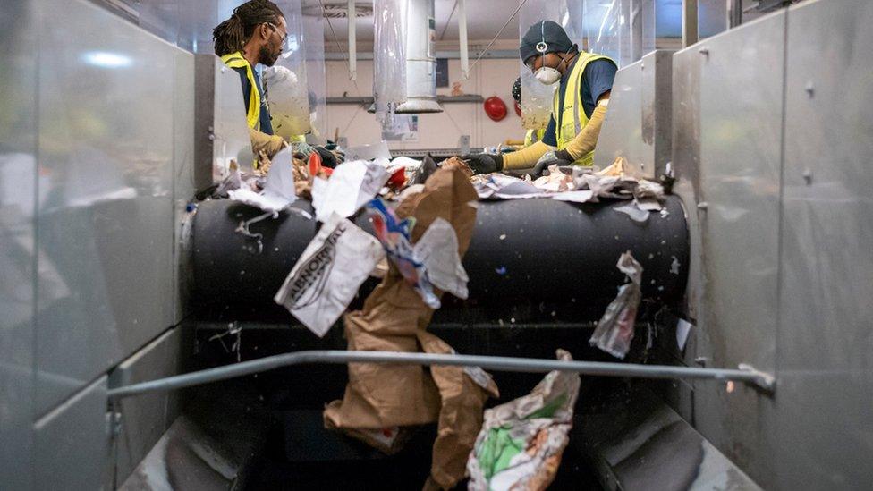 Photo of two people sorting recycling