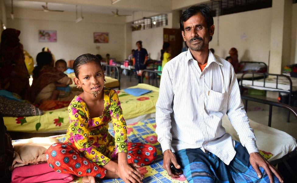 Bangladeshi patient Sahana Khatun, 10, and her father Mohammad Shahjahan pose for a photograph at the Dhaka Medical College and Hospital