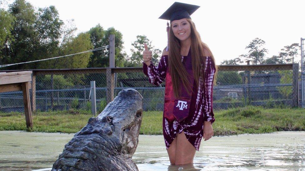 Makenzie gives thumbs up to camera posing with the alligator