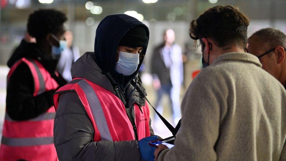 Fans have their Covid-19 status checked as they arrive ahead of the English Premier League football match between Arsenal and West Ham United.