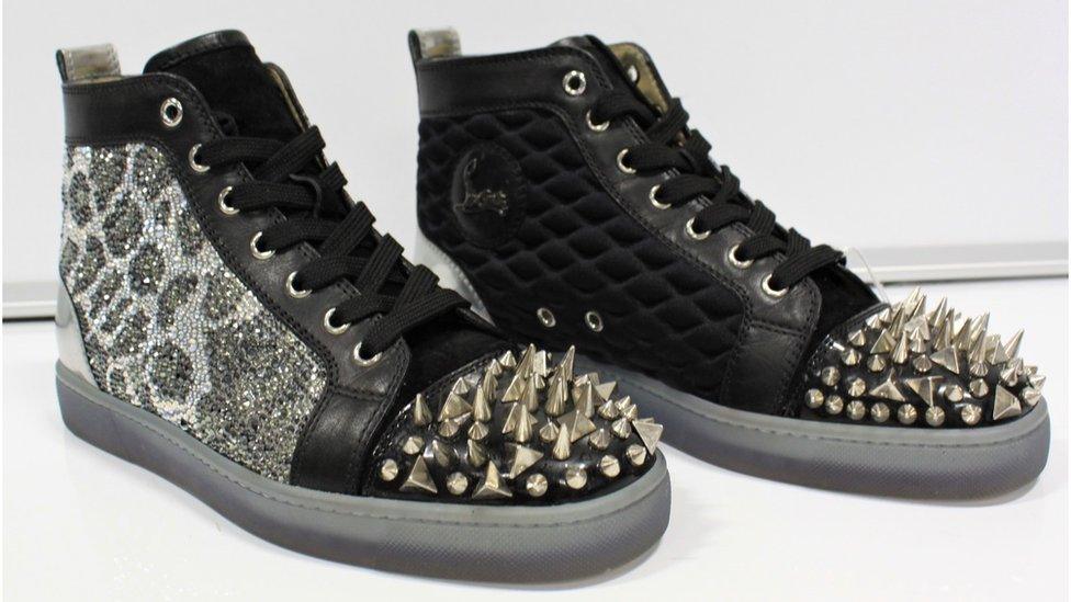 A pair of studded snake skin shoes