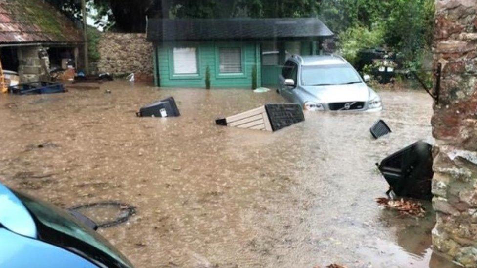 A flooded drive with cars half-submerged