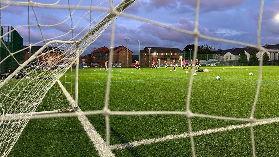 Girls training through goal netting