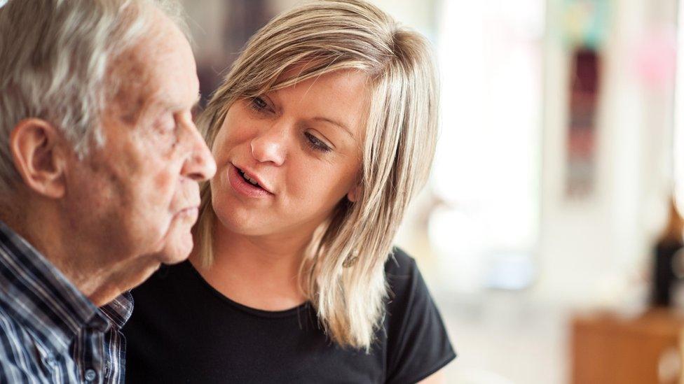 Woman helping elderly man