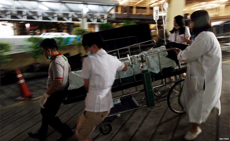 Medical workers rush the victim of a blast at the Erawan shrine to a nearby hospital in central Bangkok 17 August 2015