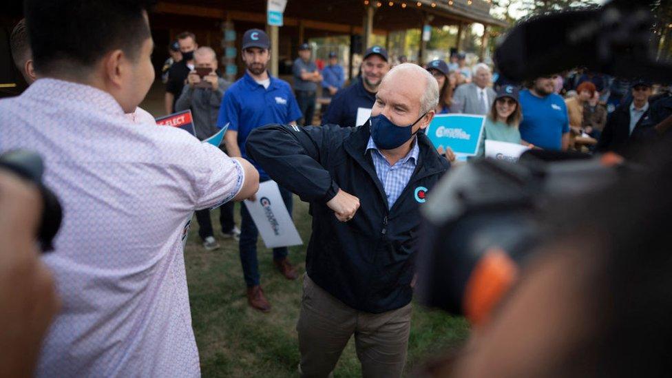 Canada's Conservative Party leader Erin O'Toole elbow bumps with a supporter as he campaigns for the 20 September General election