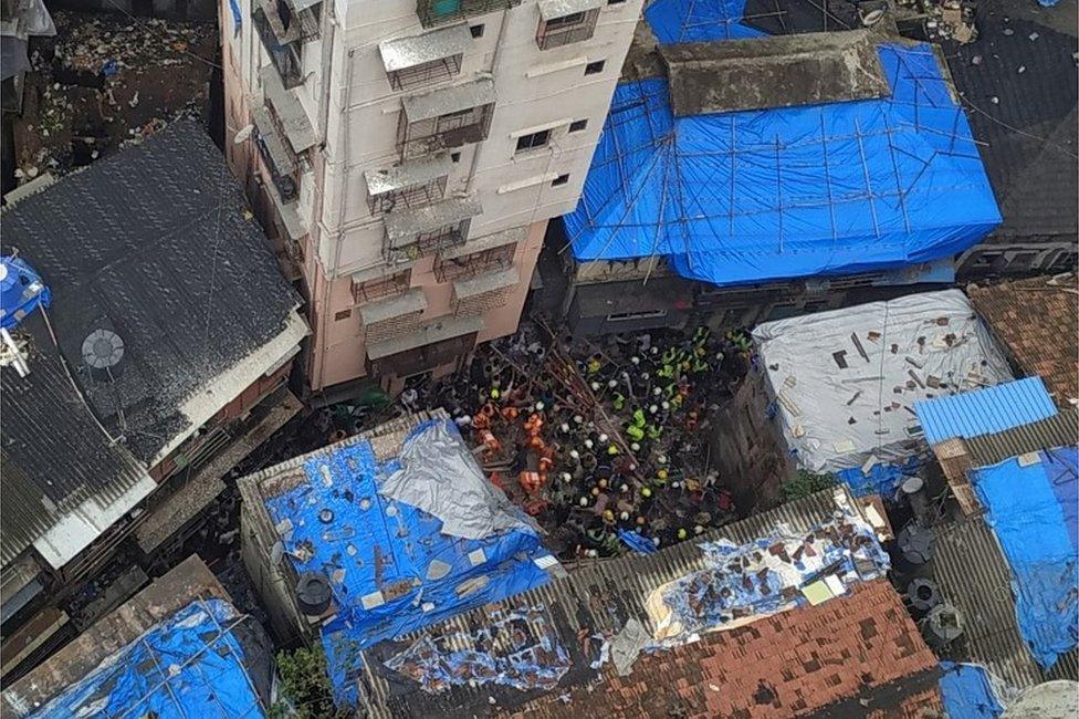 Rescue workers search for survivors at the site of a collapsed building in Mumbai, India, July 16, 2019.