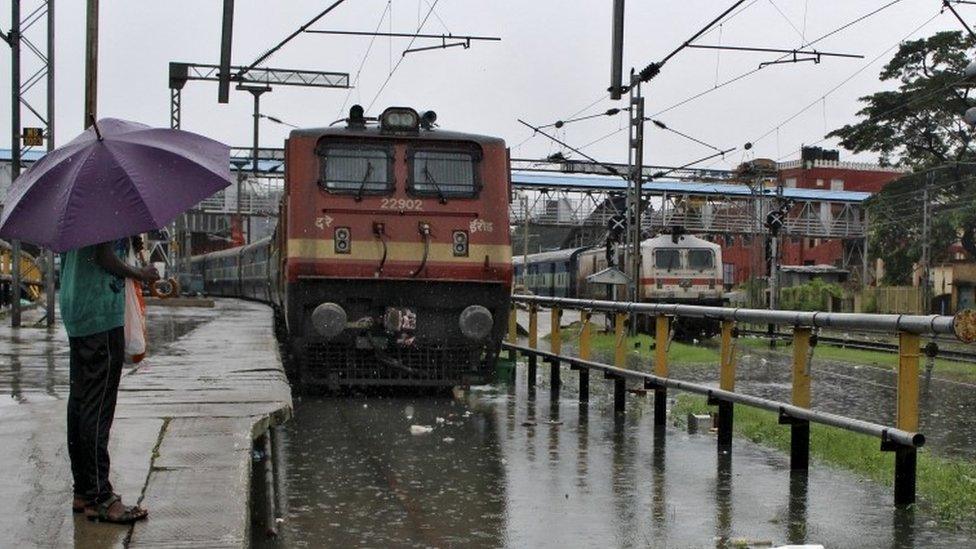 A man stands next to a flooded railway track as it rains in Chennai, India, December 2, 2015.