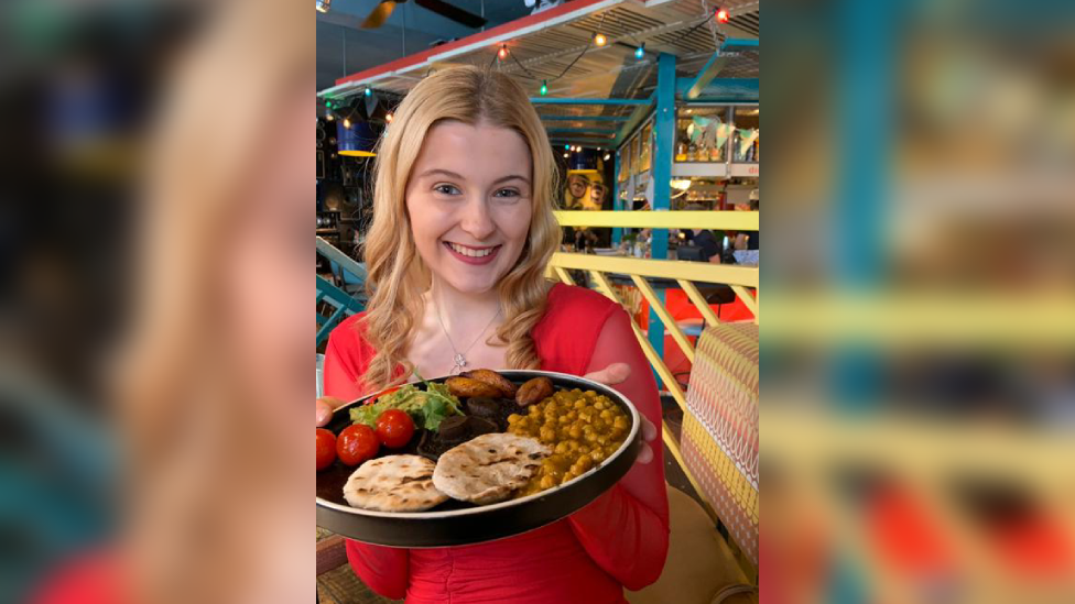 Georgia Taylor holding a plate of food