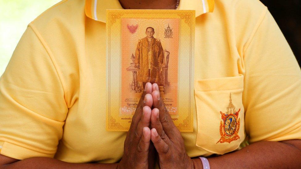 A well-wisher holds a new 70 Baht banknote to commemorate Thailand"s King Bhumibol Adulyadej"s 70th anniversary on the throne, at the Siriraj hospital where he is residing, in Bangkok, Thailand, June 9, 2016