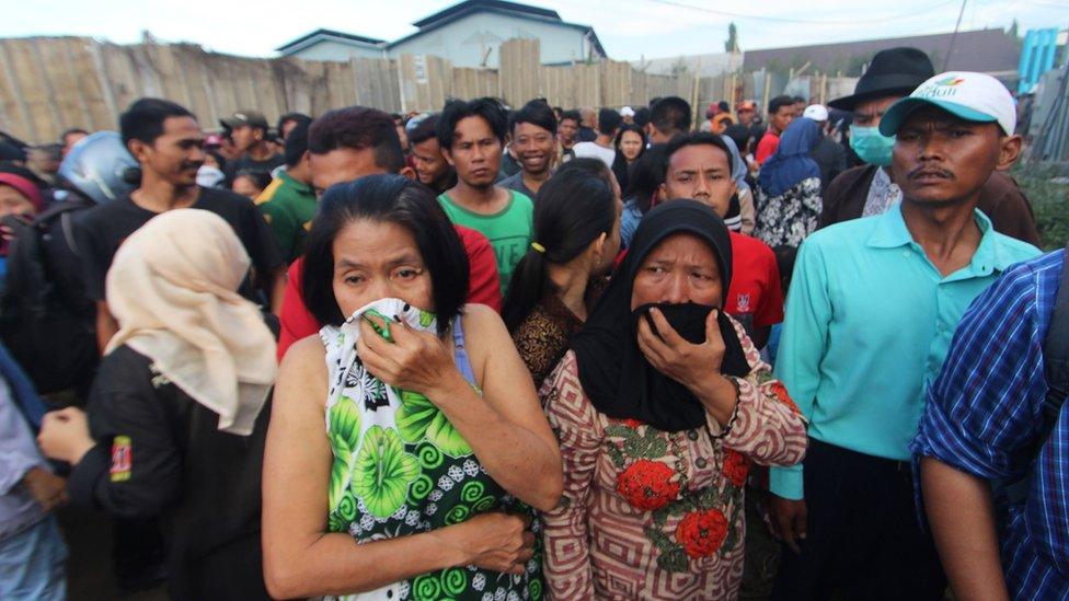 people looking at the firecracker factory that burned down