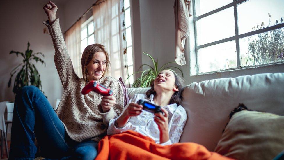 A mother and daughter play PlayStation