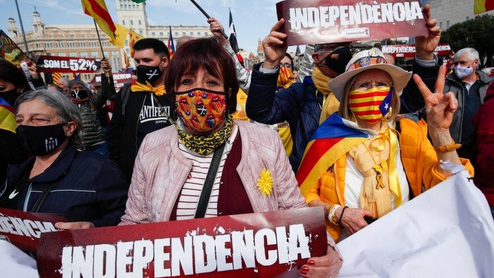 People hold signs during a protest to demand a pro-independence regional government in Catalonia, 28 February 2021