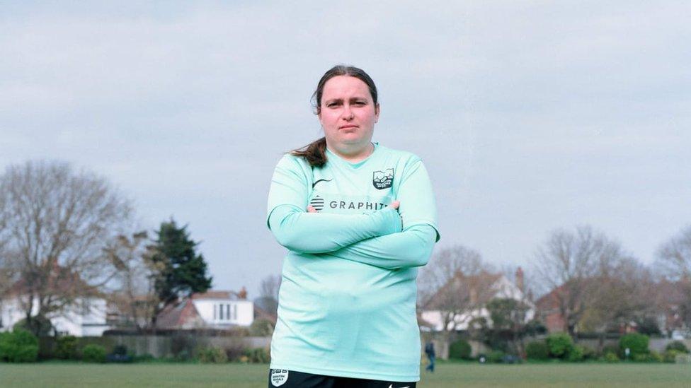 Holly Lewis, pictured outside in a football shirt