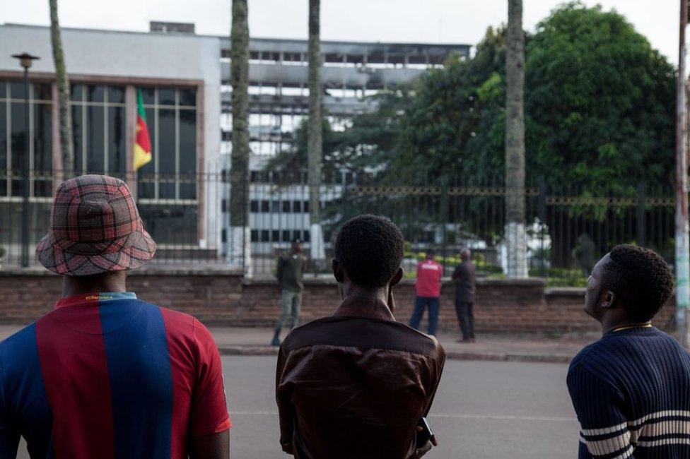 People look at the damaged building of Cameroon's parliament on November 17, 2017 in Yaounde, after a fire swept through the main building overnight, causing substantial damage.