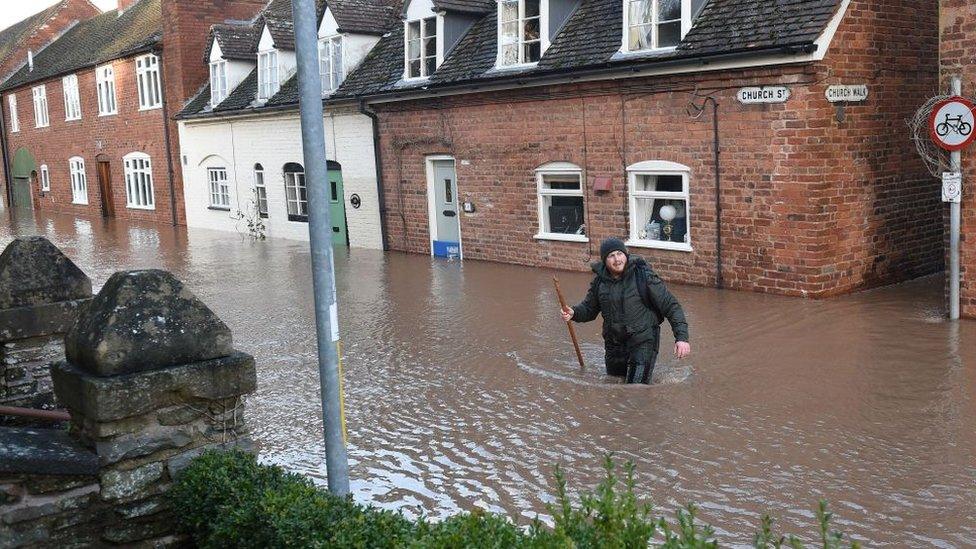 man-wading-through-water-in-Tenbury-Wells.