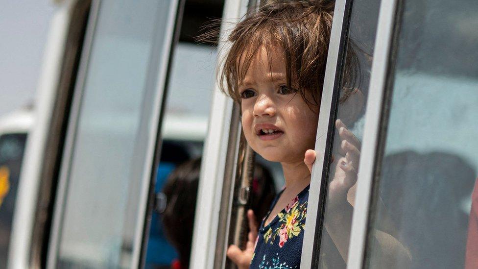 a girl stares out the window of a bus