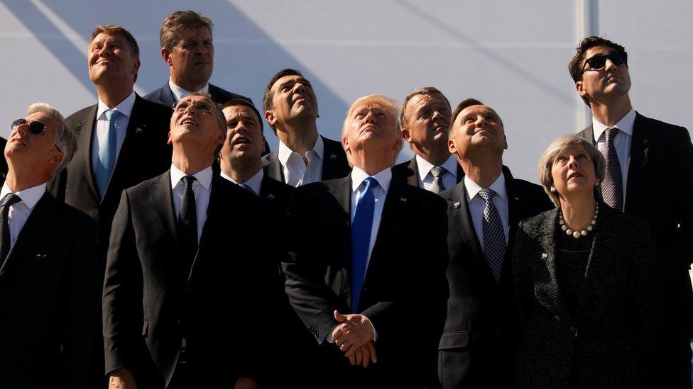 Nato leaders watch a military plane flypast