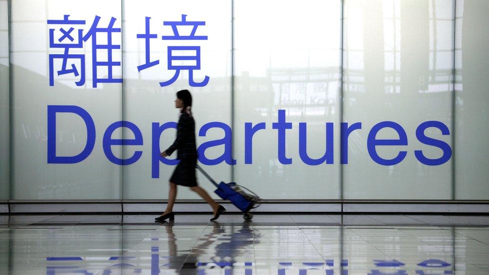 An airline stewardess heads towards a departure gate at Chek Lap Kok airport March 7, 2003 in Hong Kong