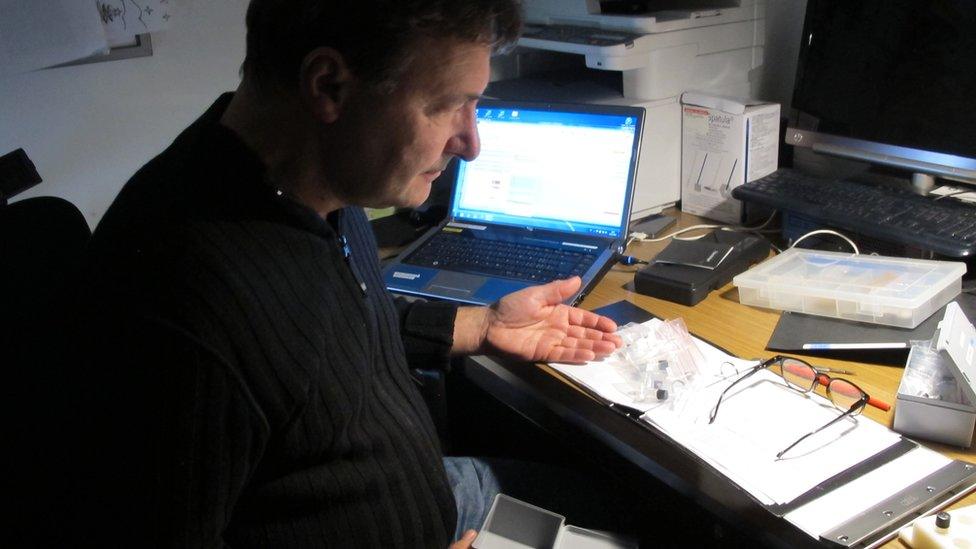 A man with drug samples on a desk