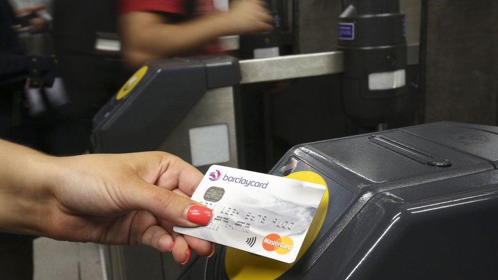 A customer at a the ticket barrier at Canary Wharf underground station