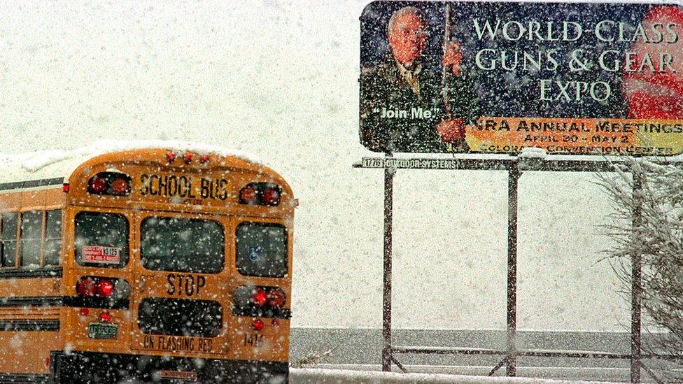 School bus drives past an NRA ad